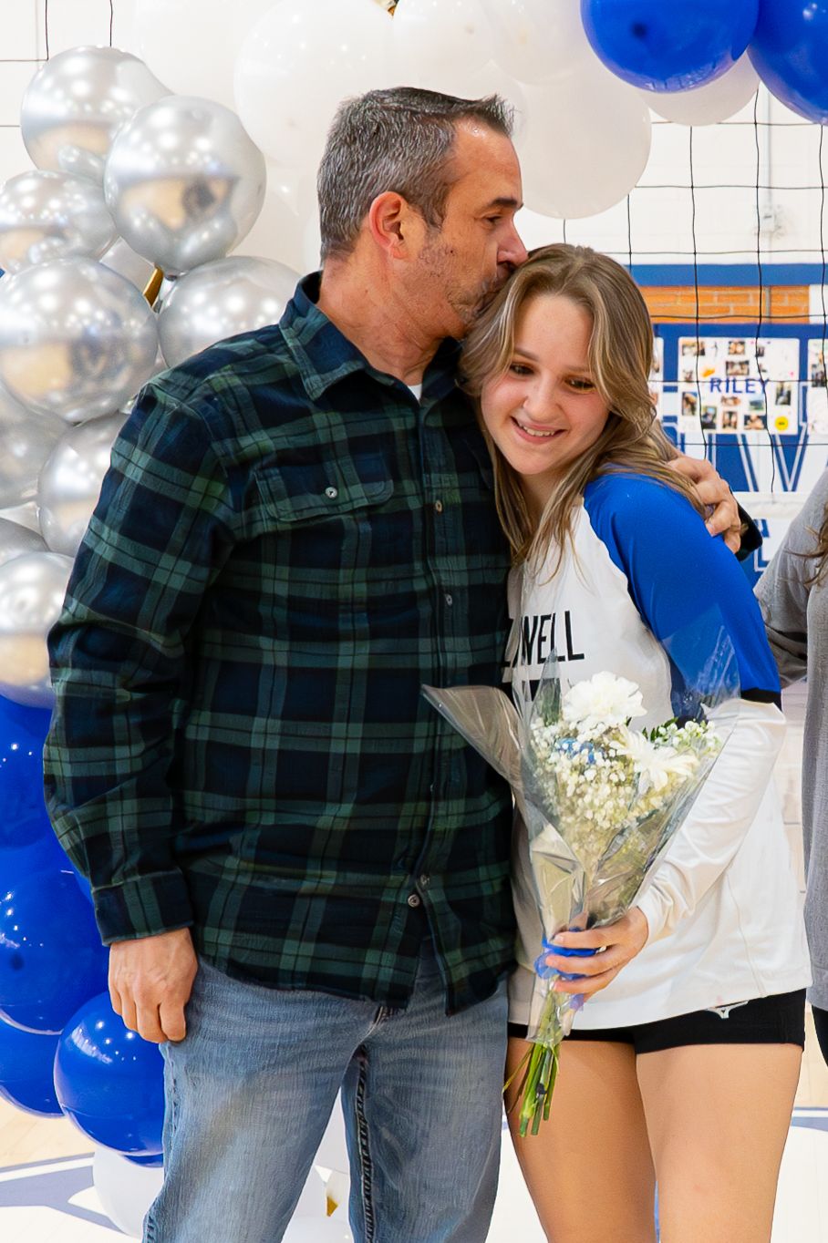 Celebration scene with blue and silver balloons in a school gym setting.