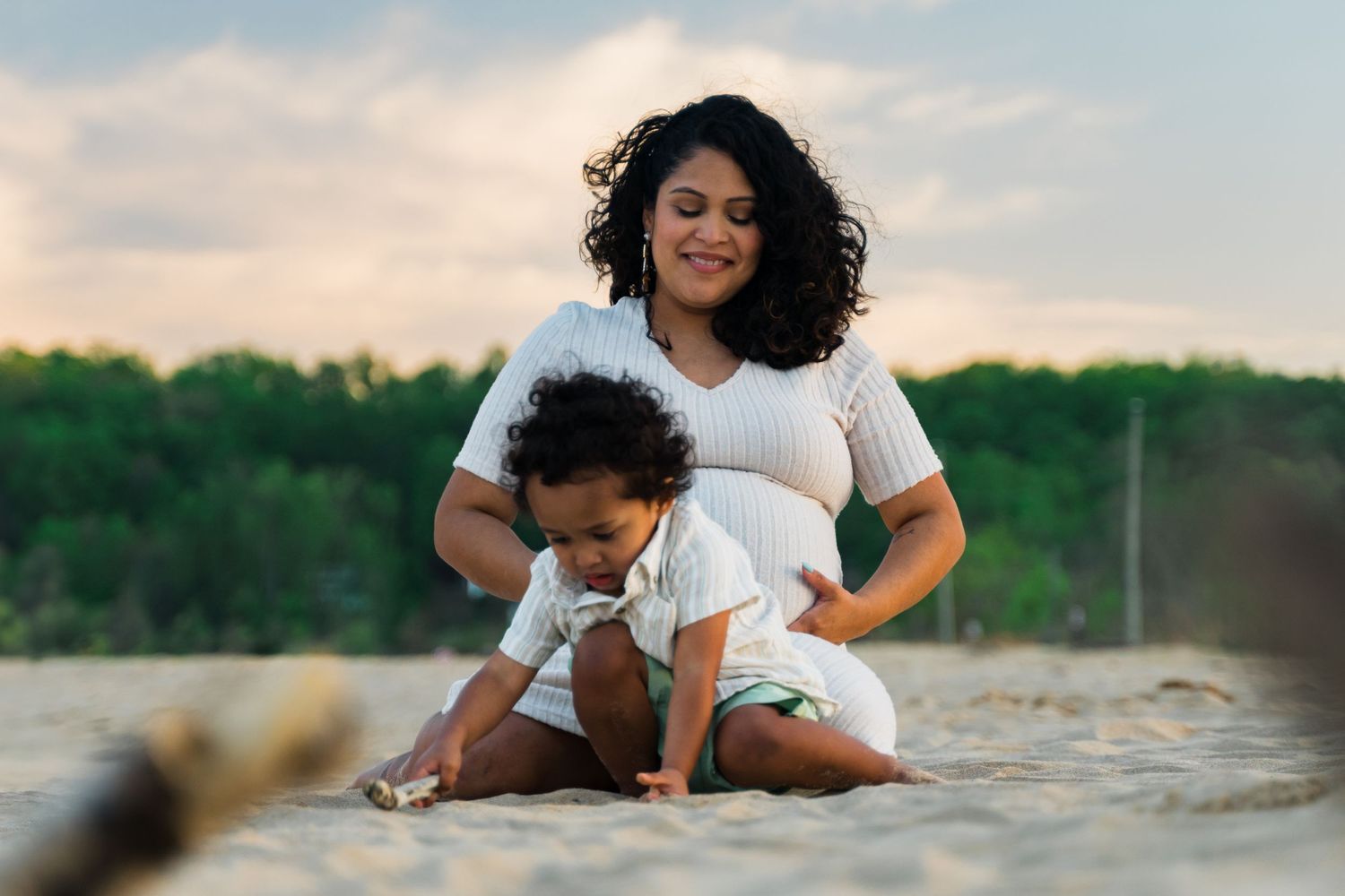 mom and son in maternity photoshoot in golden hour lighting