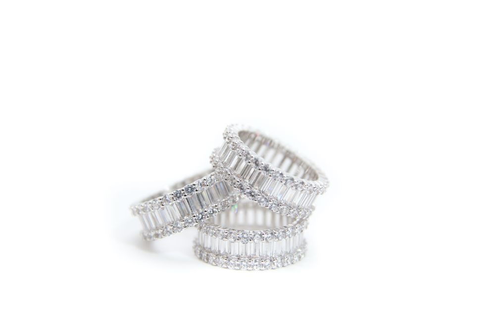 Elegant silver crystal eternity bands with baguette diamonds sparkle against white background.