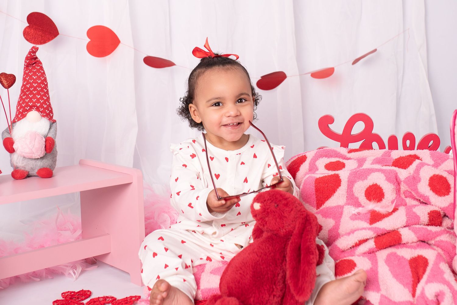 Red and white Valentine's Day themed photo collage with heart decorations and festive props.