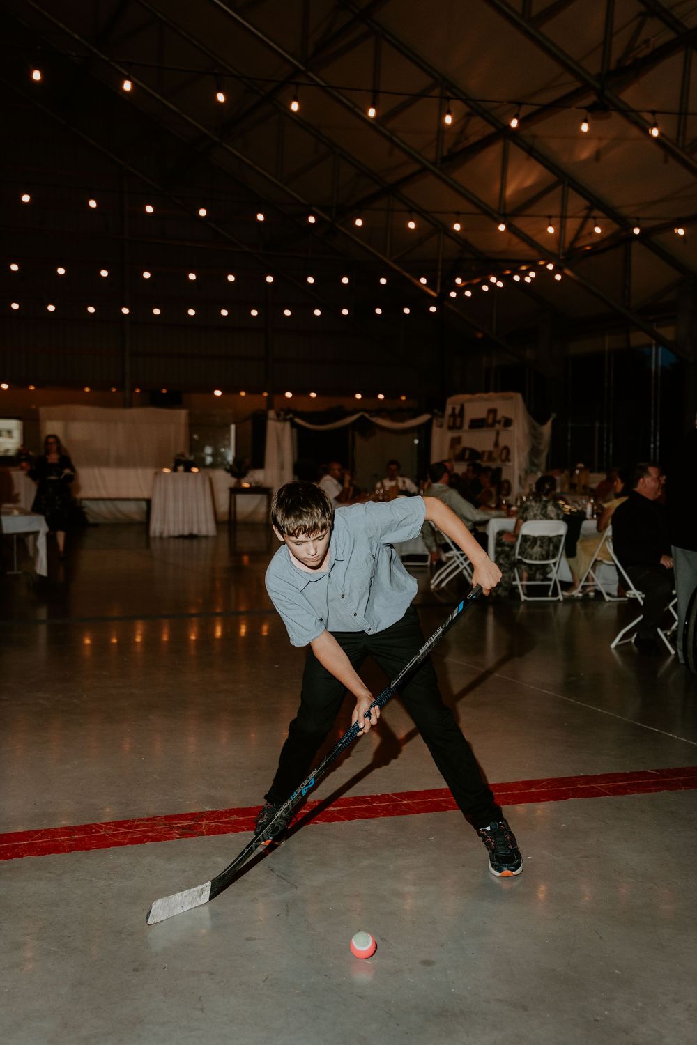 boy playing floor hockey at a wedding reception