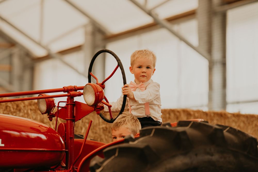 little boy on pretending to drive on an antique tractor