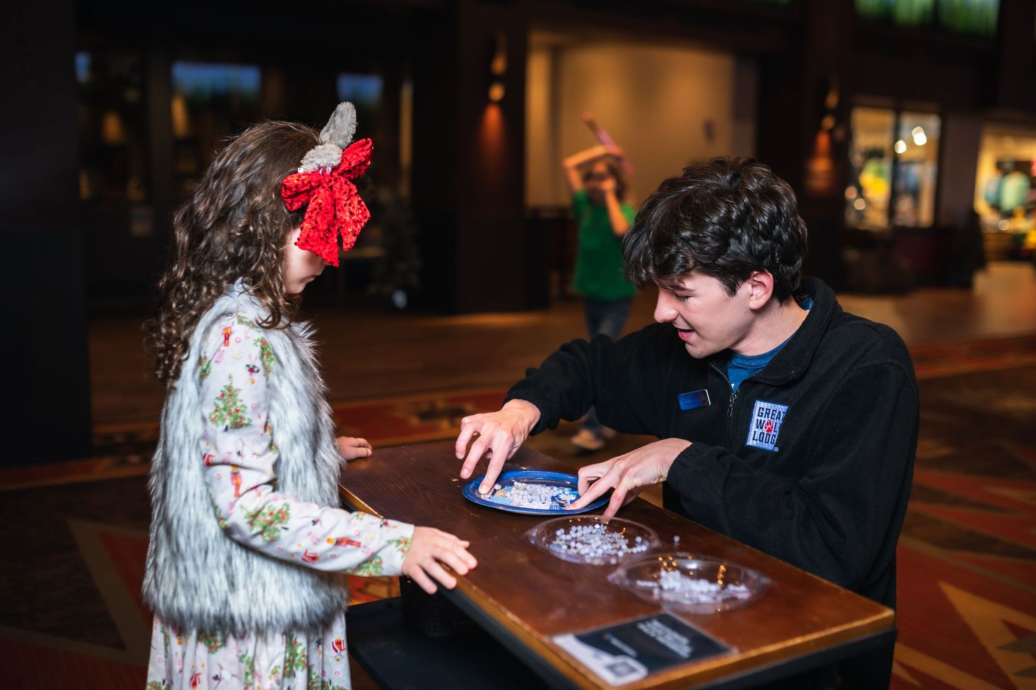 A person in a zombie costume interacts with someone at a table during a haunted house event.