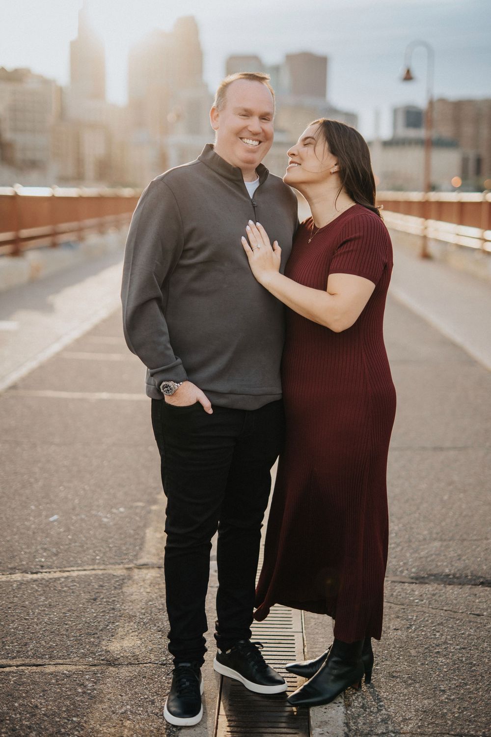 Couple sharing an intimate moment on a city street during golden hour.