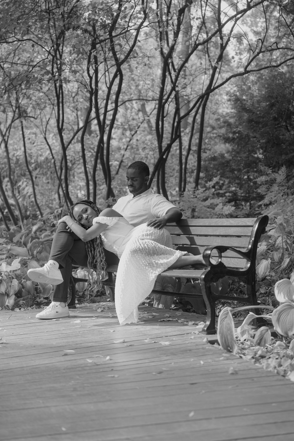 Black and white sequence of a couple dancing and spinning on an outdoor wooden deck.