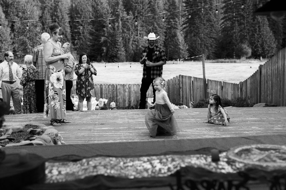 Black and white panoramic photo shows people enjoying a snowy winter day at a mountain ski resort.