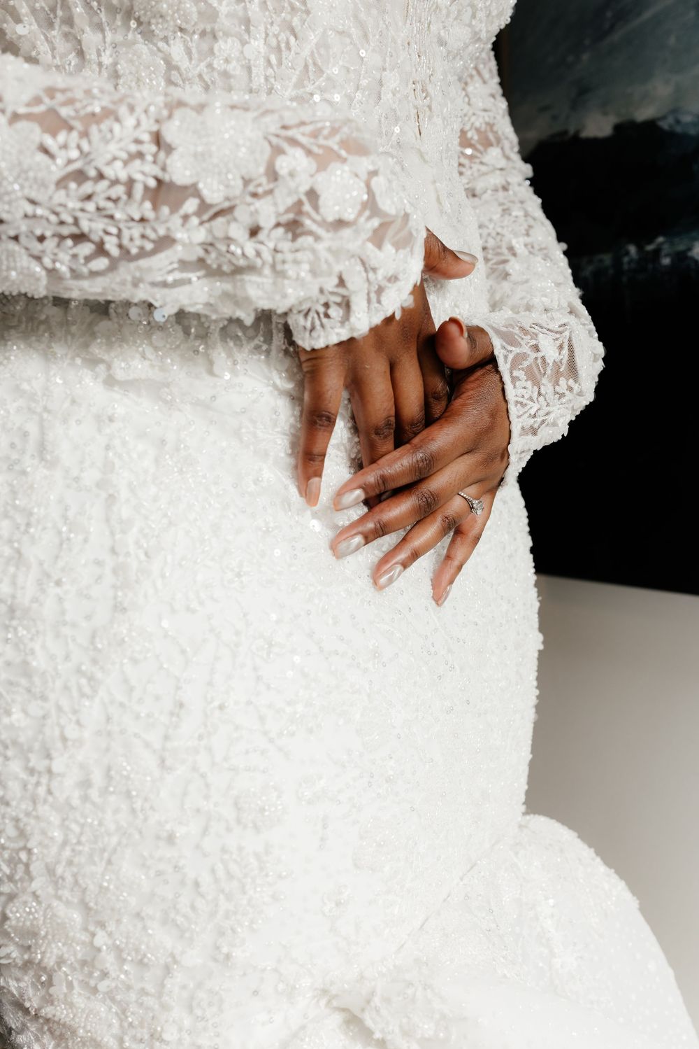 Close-up details of an elegant white lace wedding dress with delicate embroidery patterns.