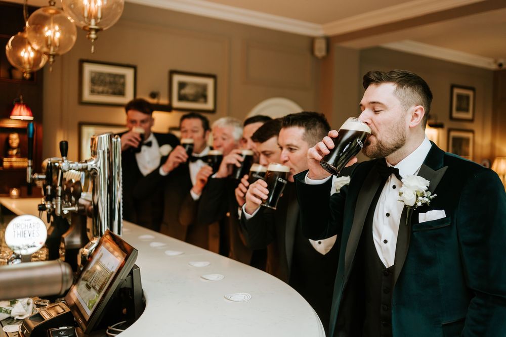 Wedding guests raise champagne glasses in a toast during an elegant indoor reception celebration. Bellingham Castle Conlon Photo & Film