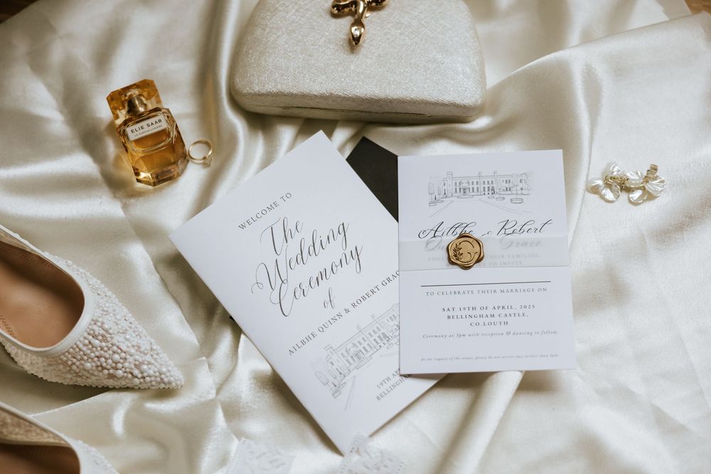Elegant wedding invitation suite with calligraphy and delicate lace details on white silk fabric. Bellingham Castle Conlon Photo & Film