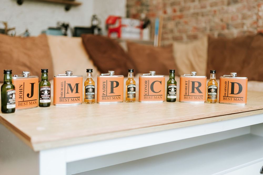 Wooden alphabet blocks spelling 'IMPAIRED' arranged between beer bottles on a white surface against a brick wall. Bellingham Castle