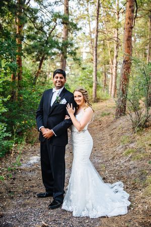 A wedding photoshoot in a pine forest shows playful and romantic moments between newlyweds.