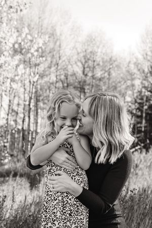 Mother and child sharing tender moments in black and white outdoor portrait series.