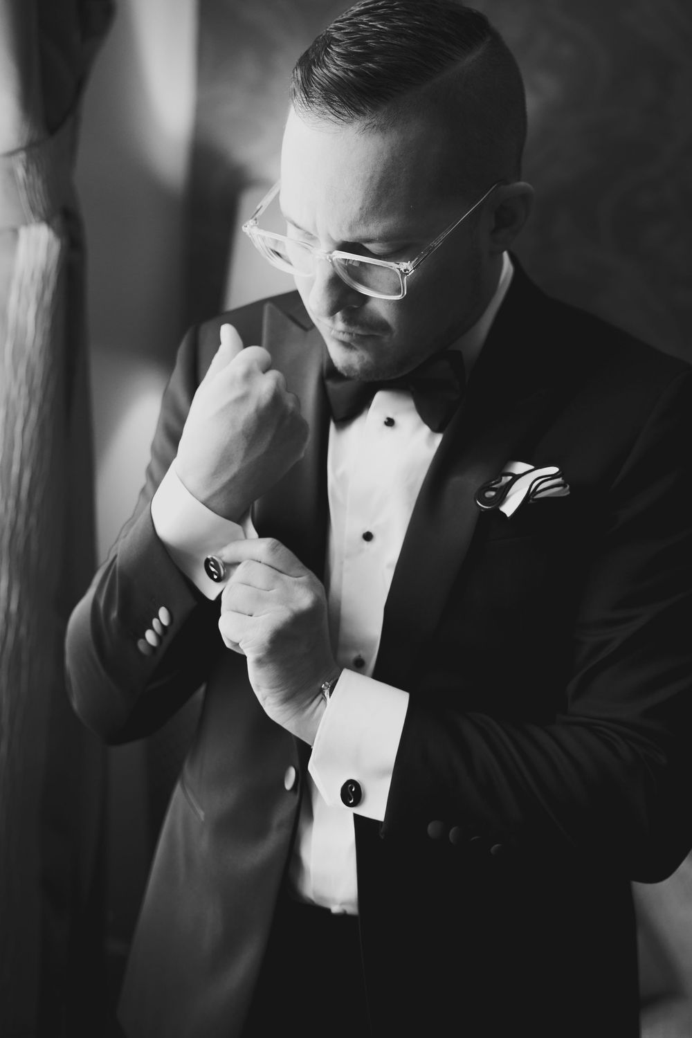 Black and white photo series showing an emotional moment of someone wiping tears while wearing a formal tuxedo.