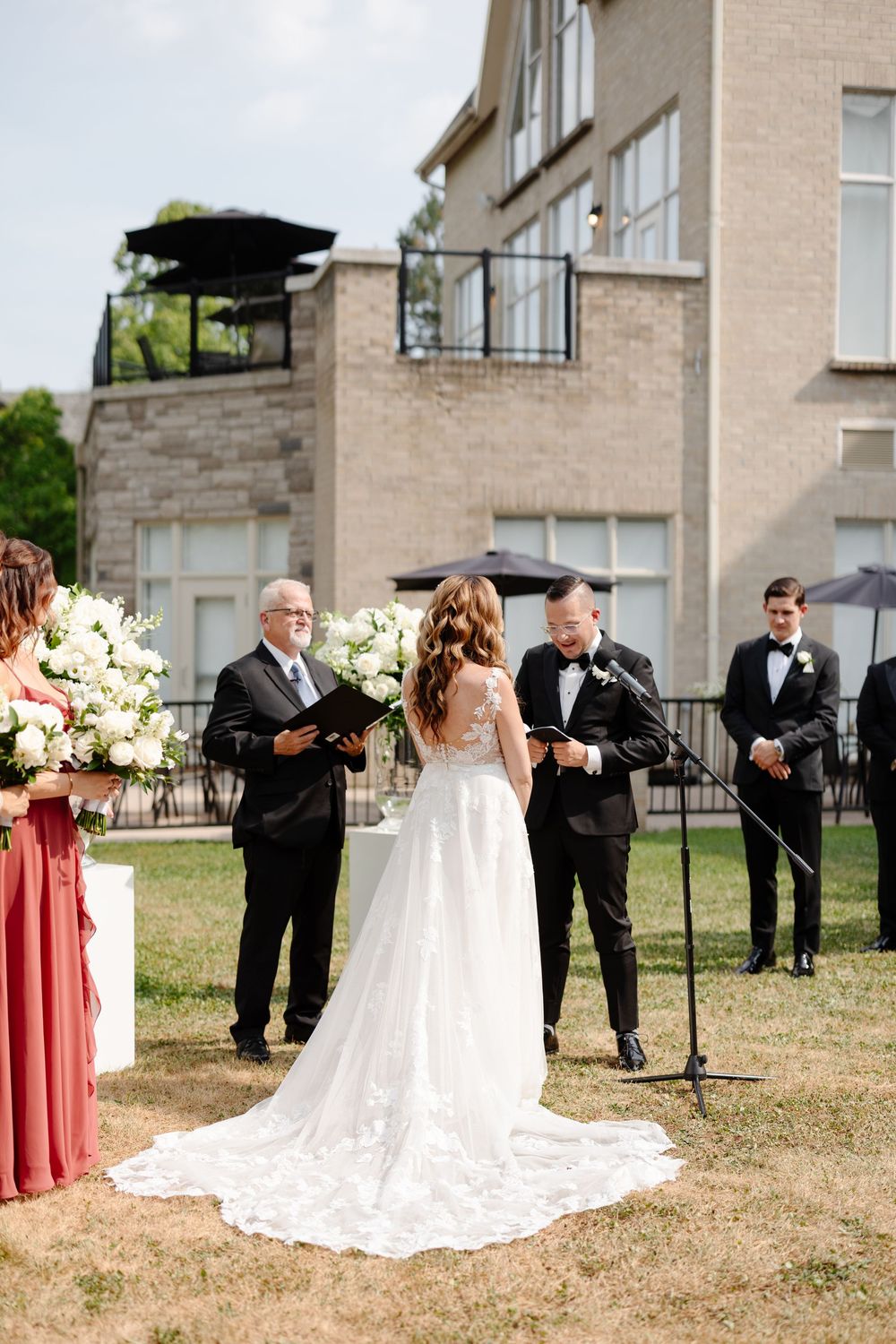 Wedding party poses in sequence on grassy lawn with elegant white gown and pink bridesmaid dresses visible.