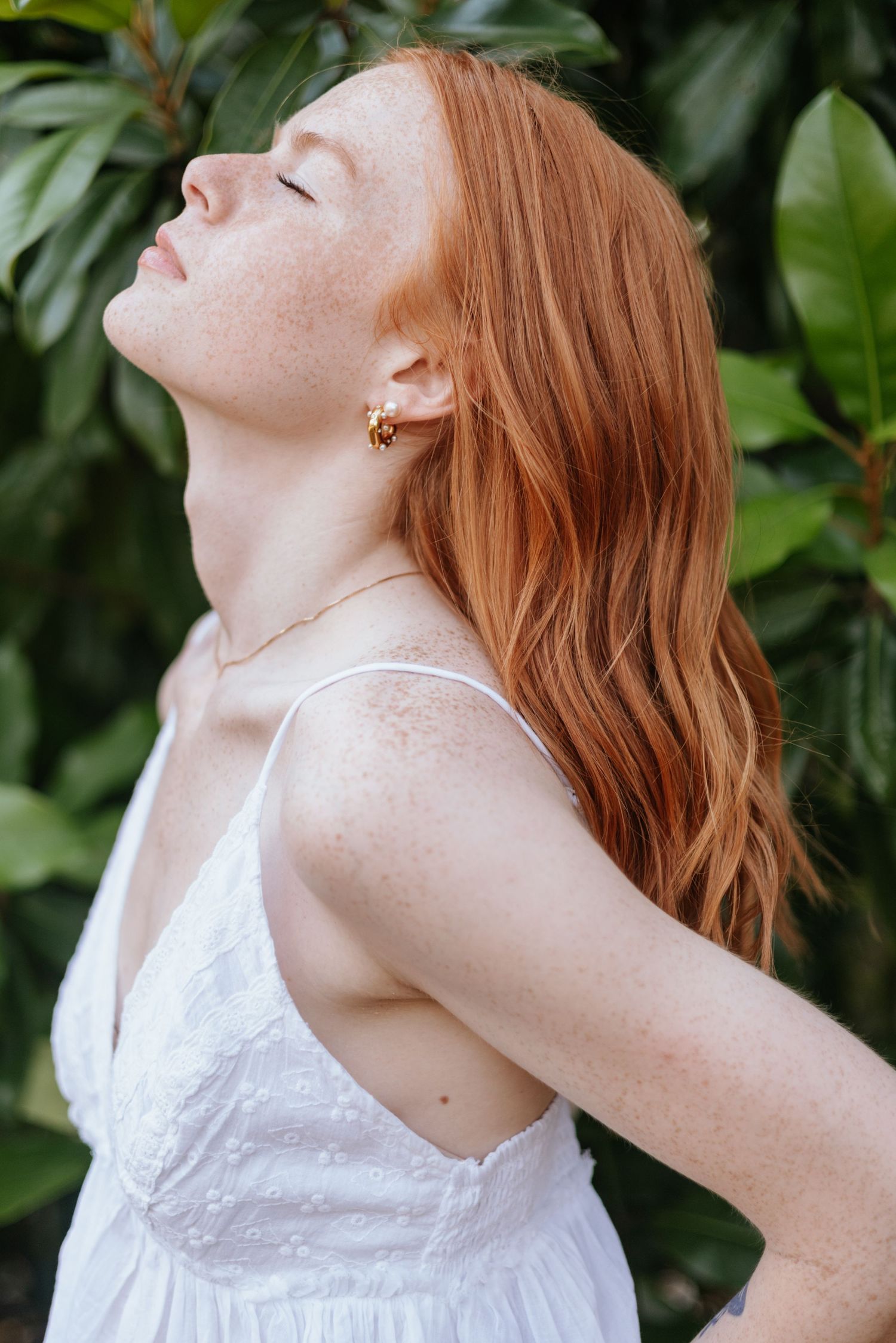 Portrait series showing woman with red hair against green foliage background.