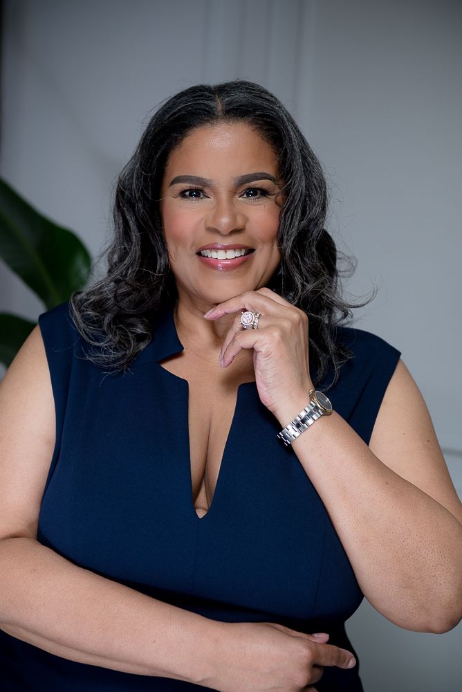 Professional portrait series showing a person in a navy blue sleeveless top with jewelry against a gray background.