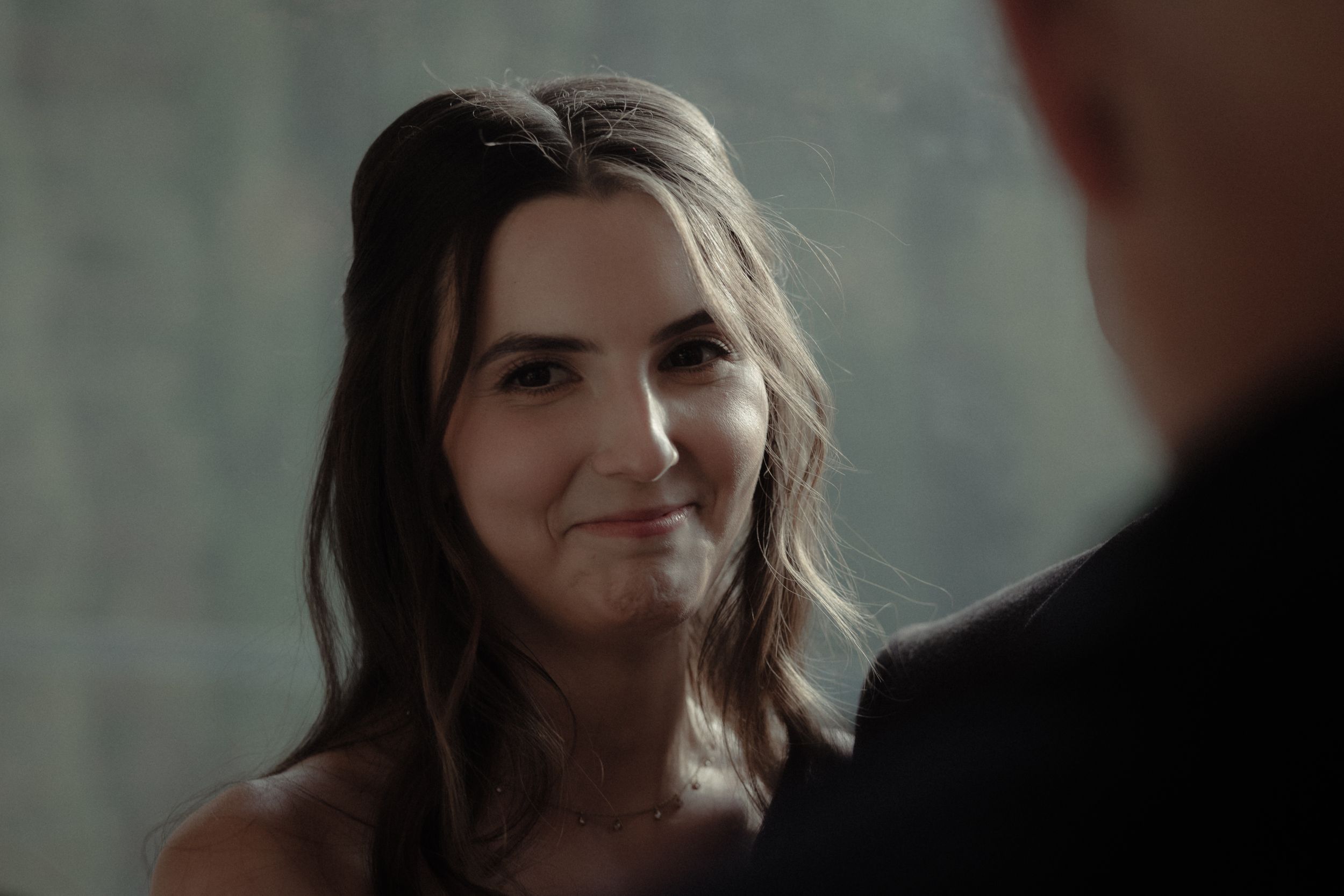 A warm exchange between attendees at an intimate indoor gathering with soft lighting.