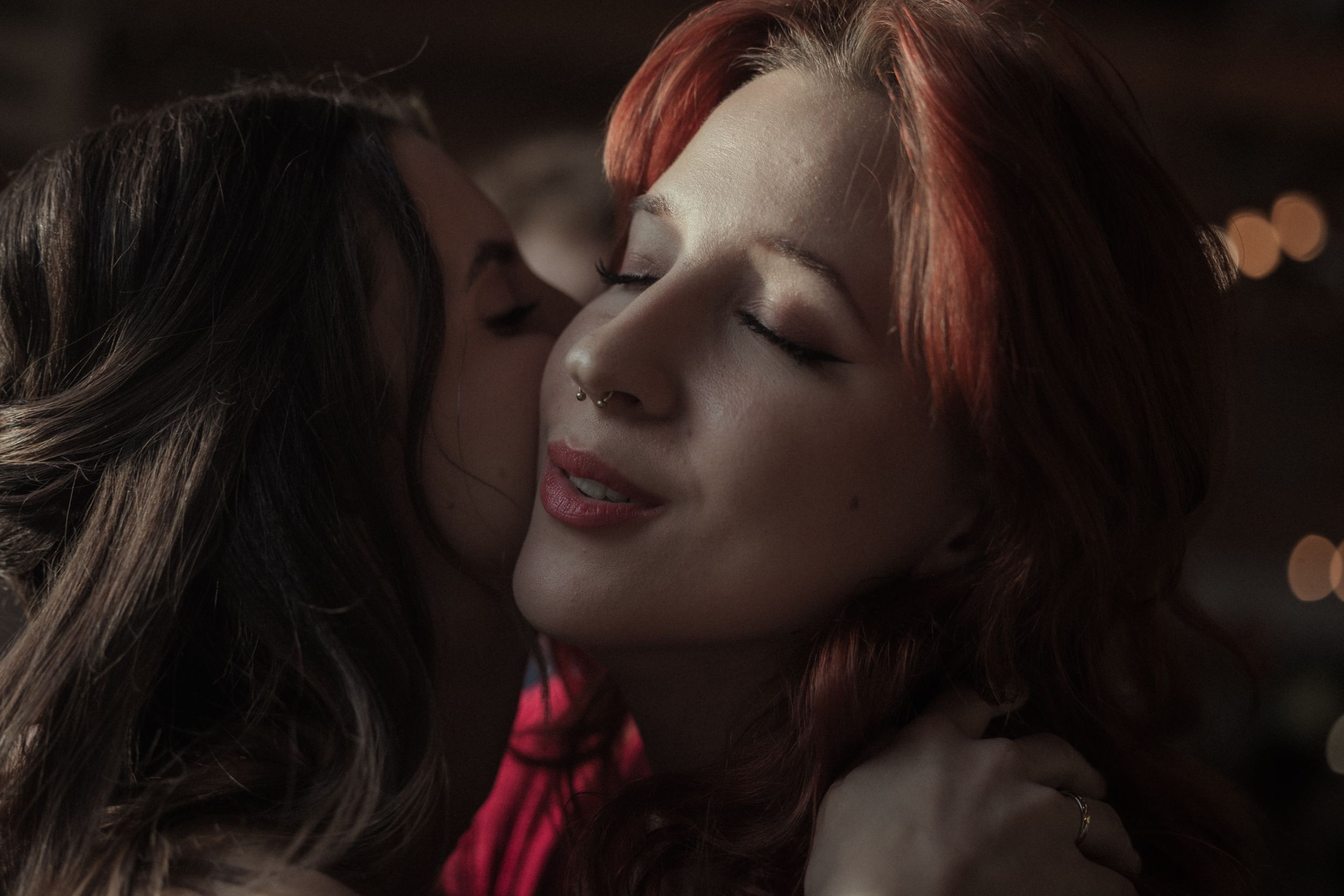 A collage of artistic portraits showing a person in dramatic lighting wearing red lipstick against dark backgrounds.