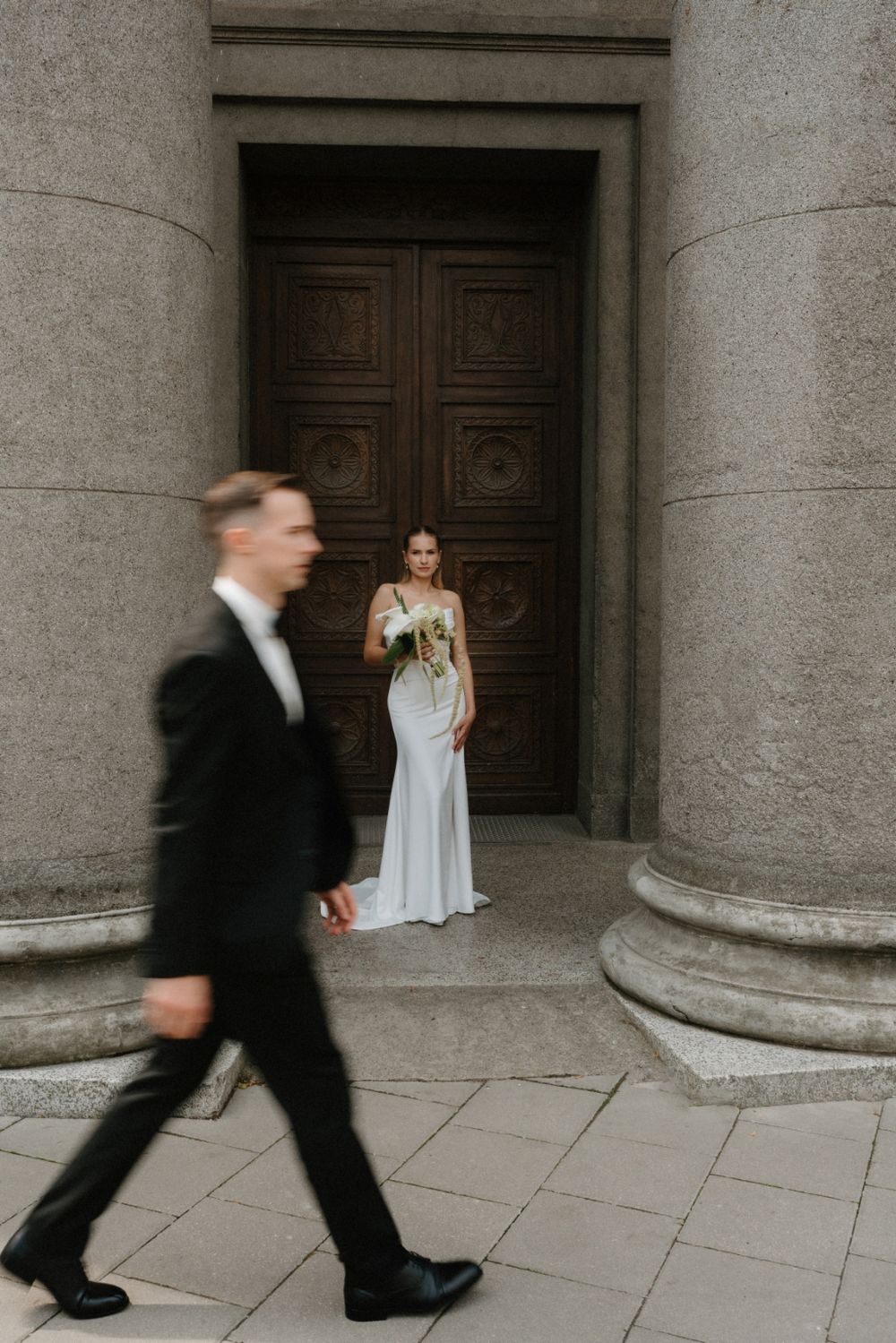 Creative wedding sequence showing movement between classical stone pillars.