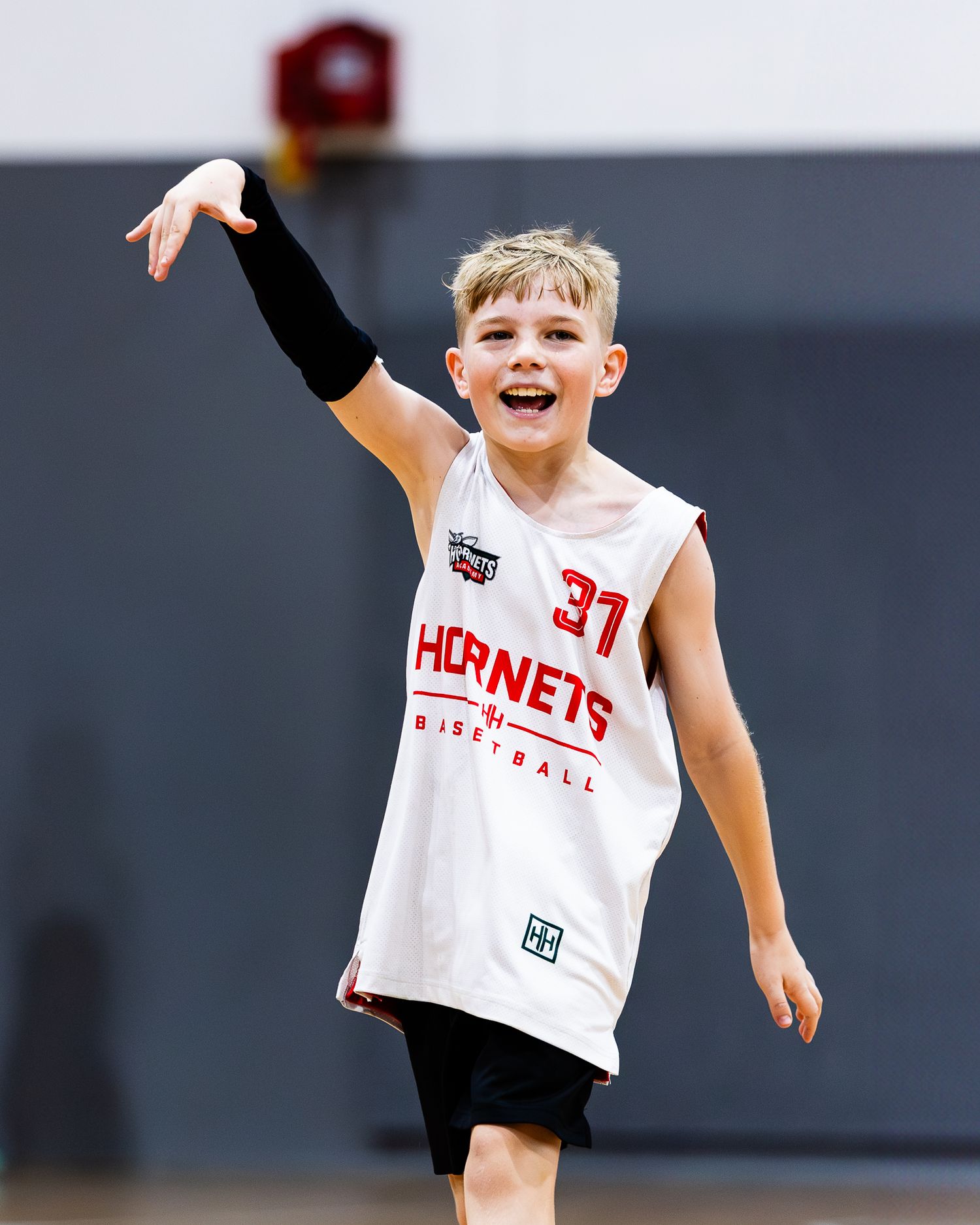 Young basketball players in white jerseys practicing and celebrating during a game.