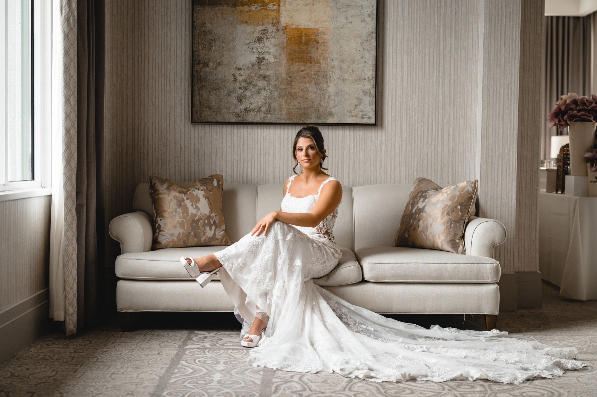 Artistic bridal portraits taken in an elegant room with white furniture and natural lighting.