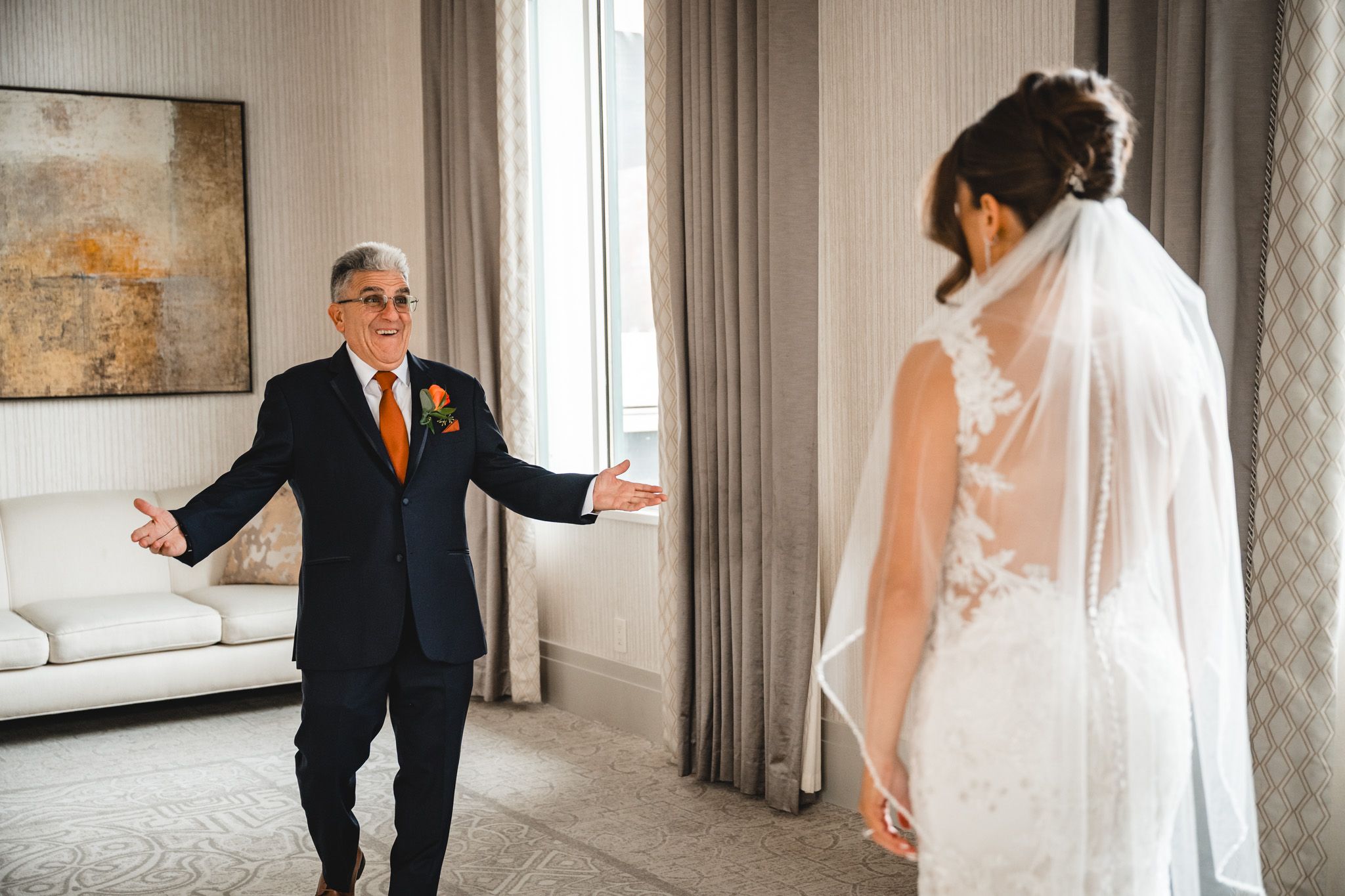 A series of emotional first look moments between a bride and her loved ones in an elegant indoor setting.