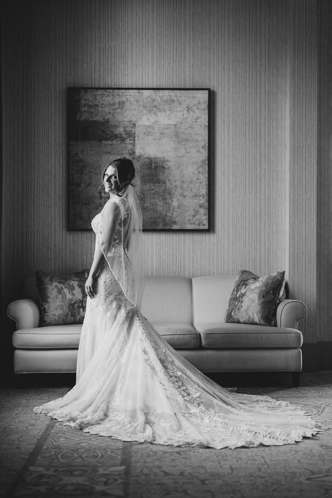 Dramatic black and white photos of a wedding dress with intricate lace details and flowing train.