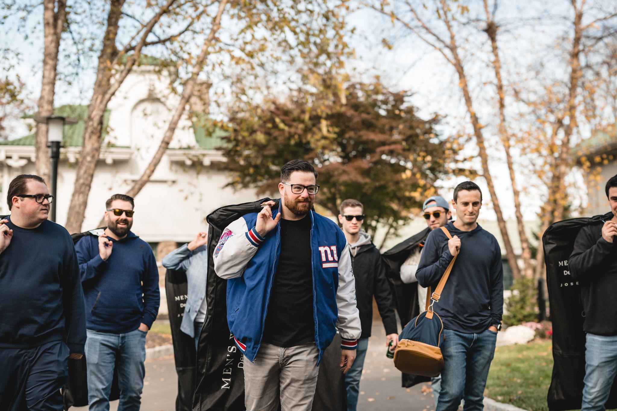 Casual outdoor gathering of guests in casual attire against a natural backdrop with trees.