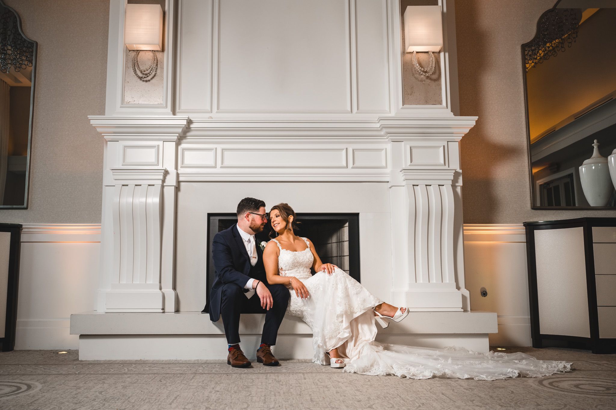 Elegant white wedding reception venue with classic architectural details and soft lighting.