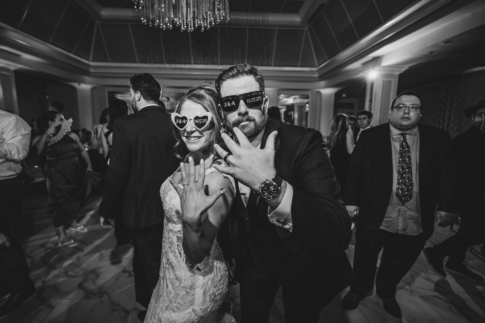 Wedding guests dancing and having fun with sunglasses on the dance floor.