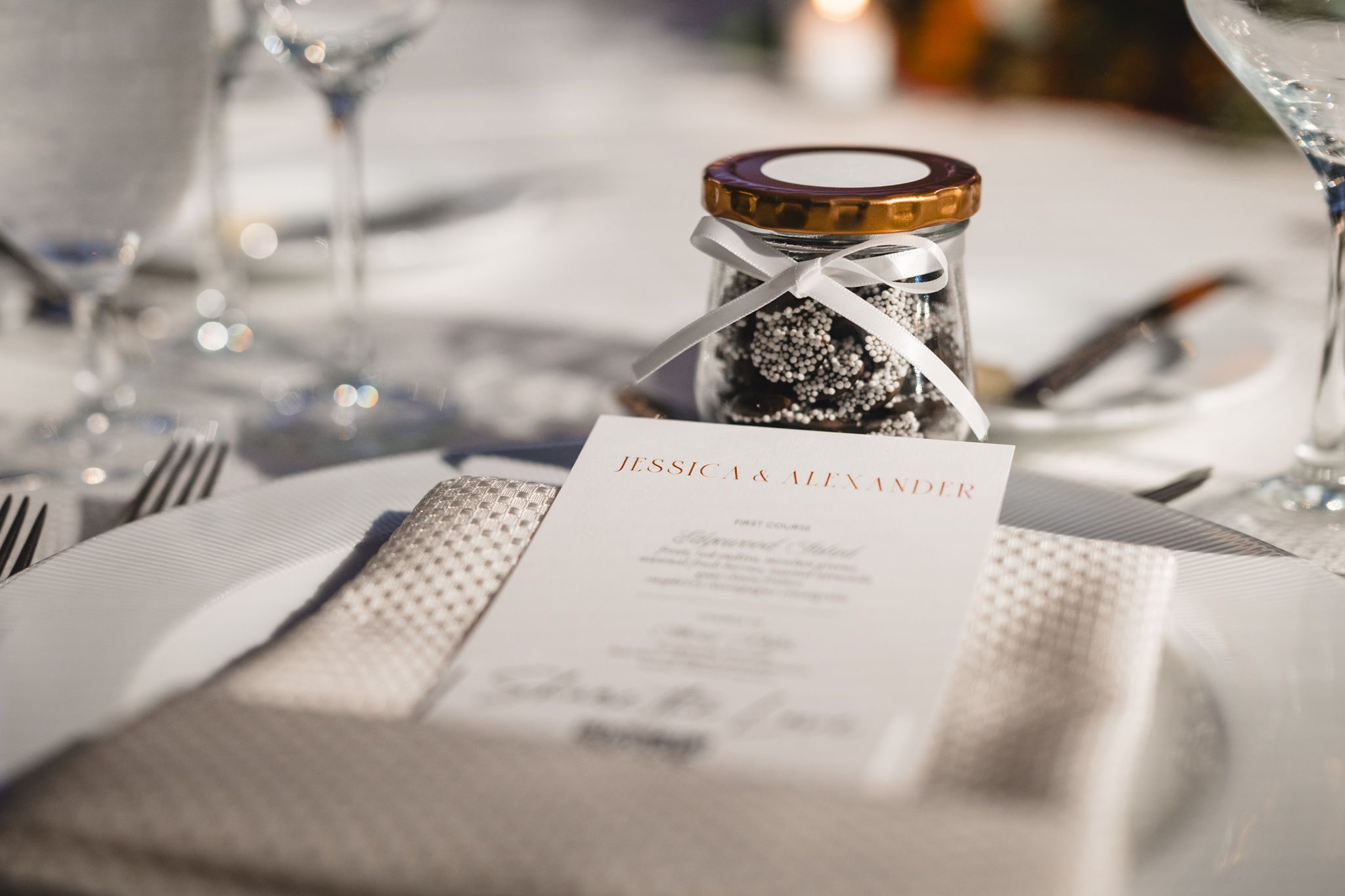 Elegant table settings with white linens and glassware at a formal event.