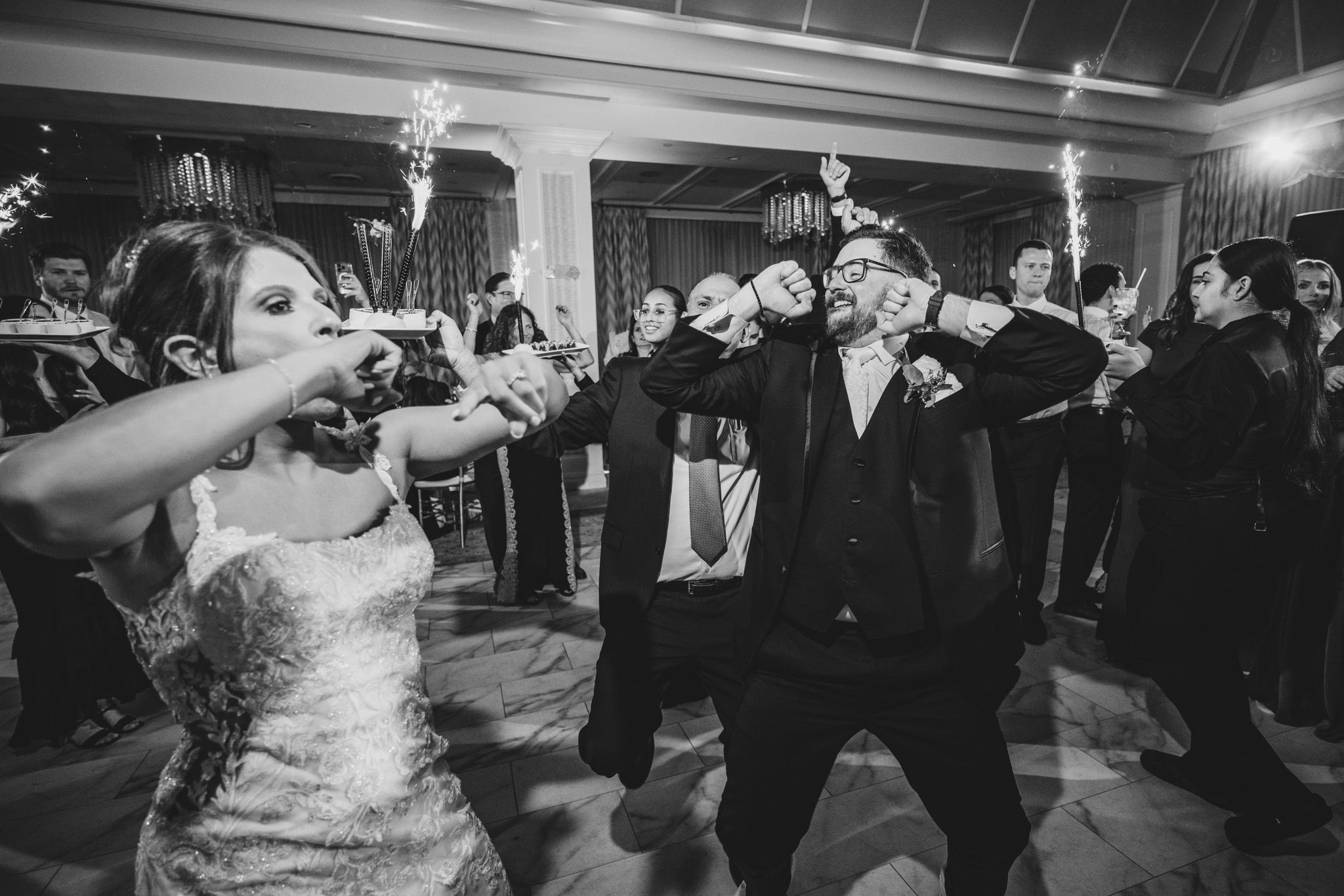 Wedding guests dancing in formation during a choreographed moment at the reception.