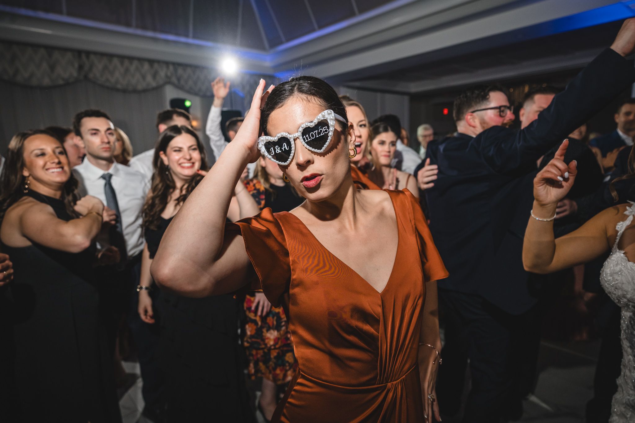 Wedding celebration with guests dancing under dramatic blue lighting effects.