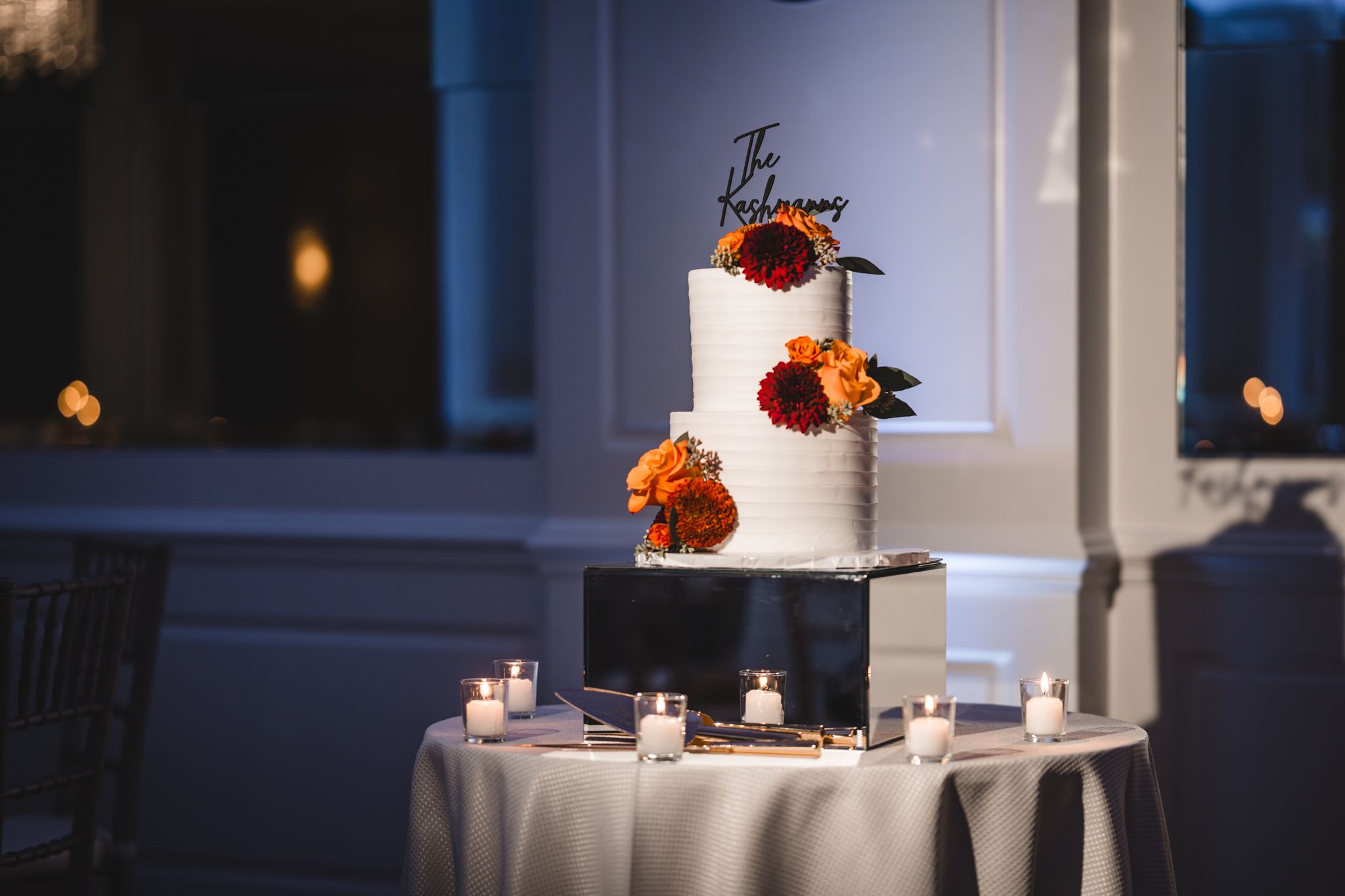Intimate reception room with moody lighting and elegant floral centerpieces.