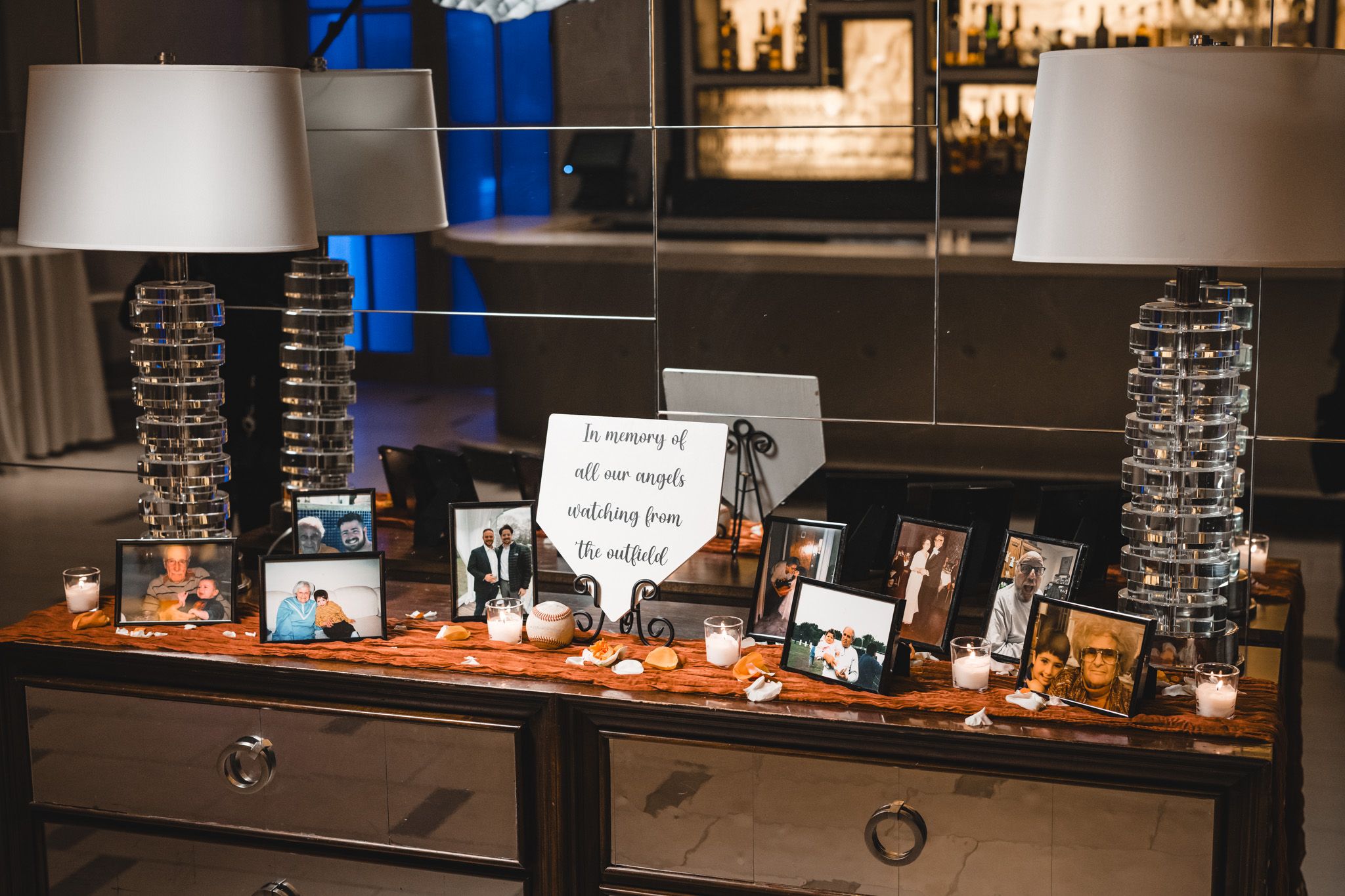 Bar setup with blue accent lighting and display shelves of spirits and glassware.