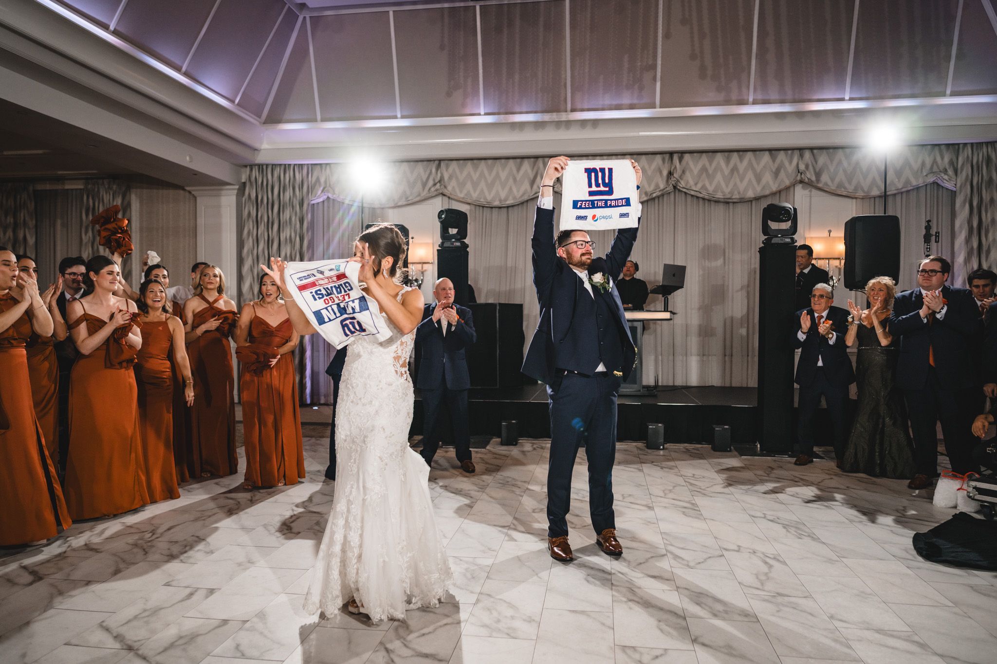 Wedding celebration in an elegant ballroom with guests watching the festivities.