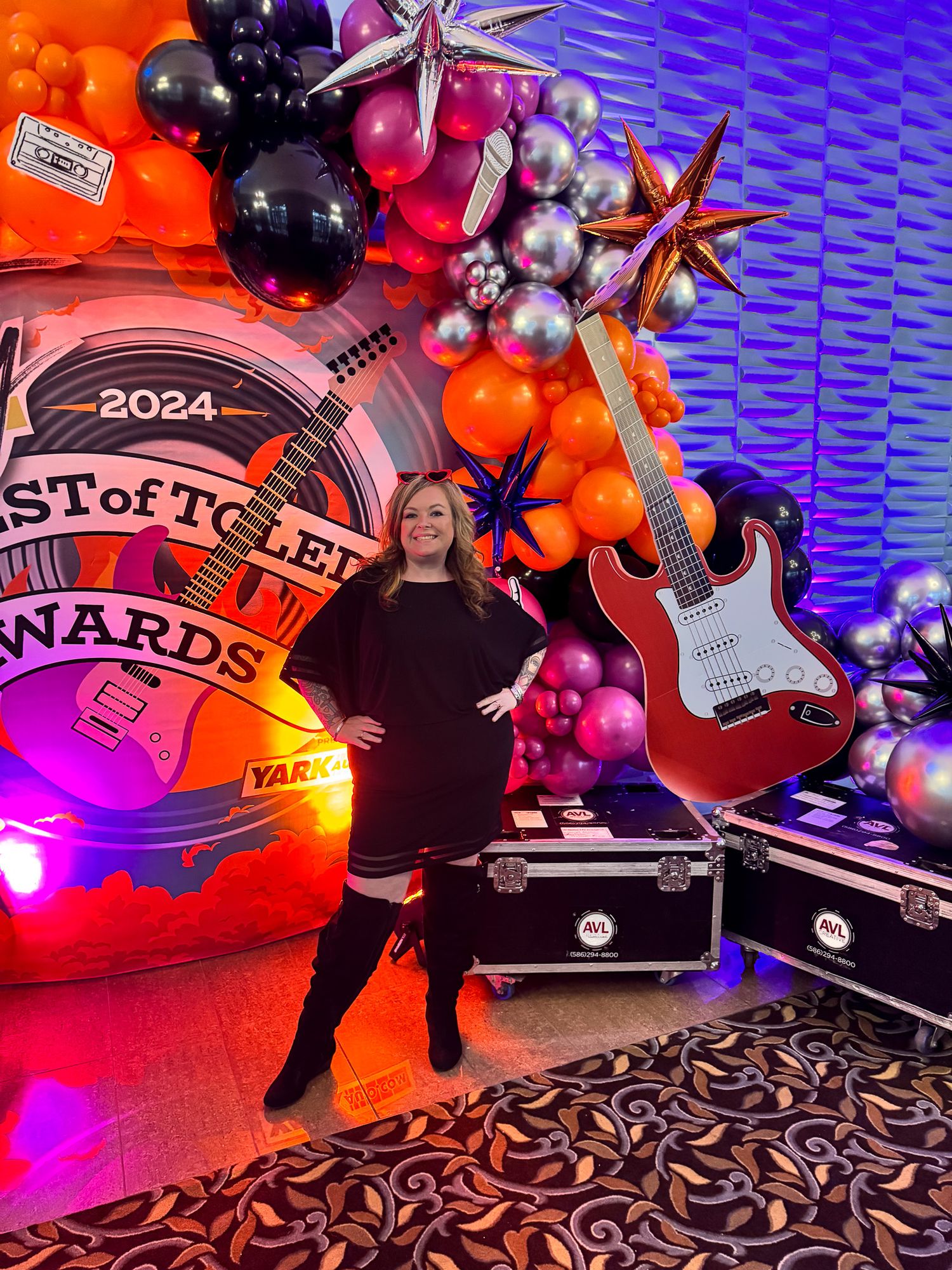 Colorful event setup with balloon arch, electric guitar prop and 2024 Best of Toledo Awards signage against purple lighting winner.