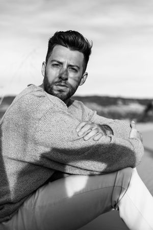 Black and white portrait series showing contemplative poses against a blurred background.