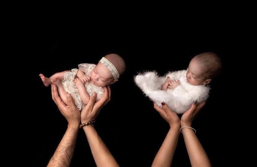 Series of black and white photographs showing hands holding a sleeping newborn baby in different poses.