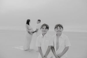 A series of intimate black and white beach portraits showing gentle interactions.