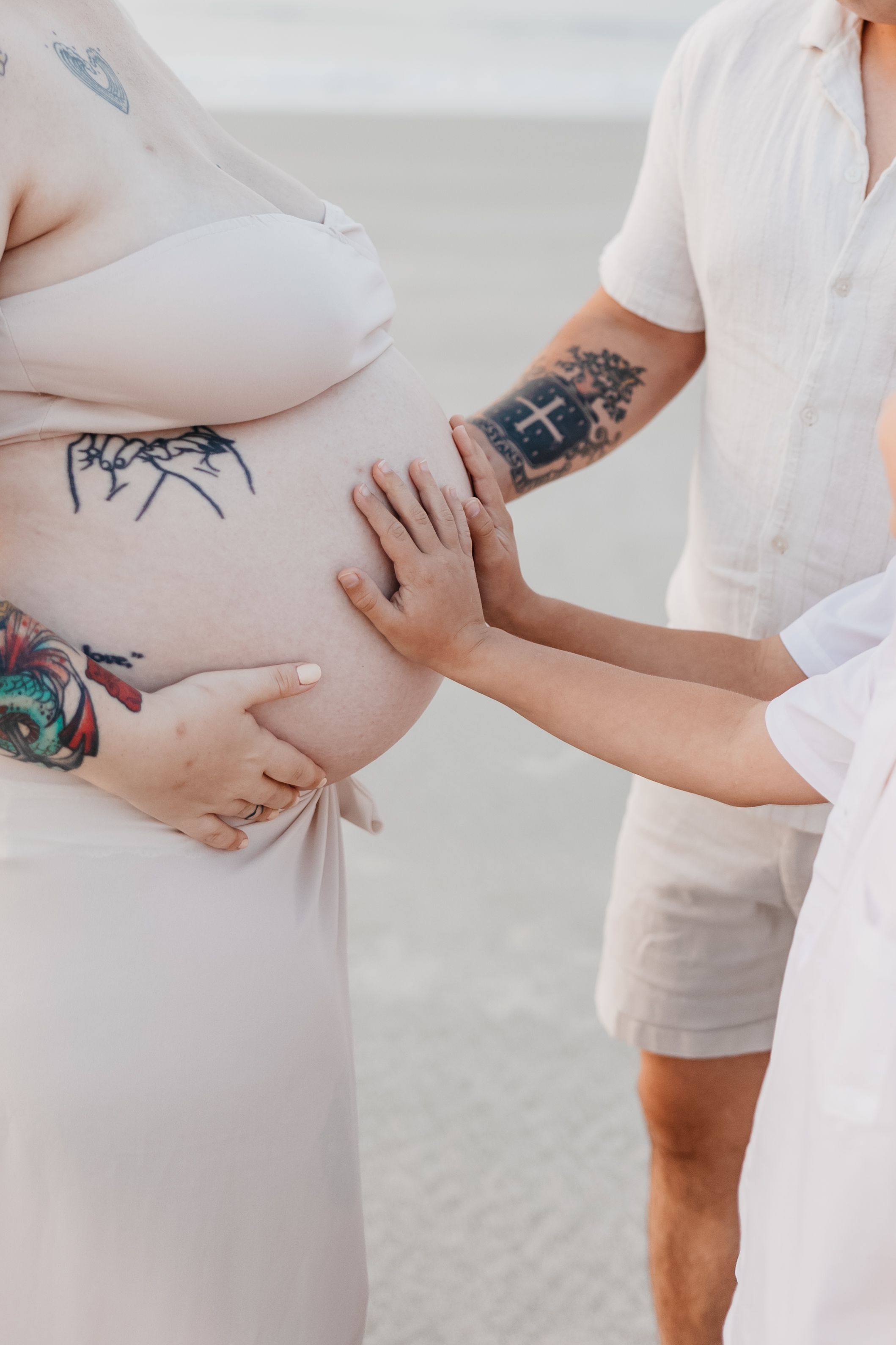 Close-up shots showing tattooed arms and gentle touches in white attire.