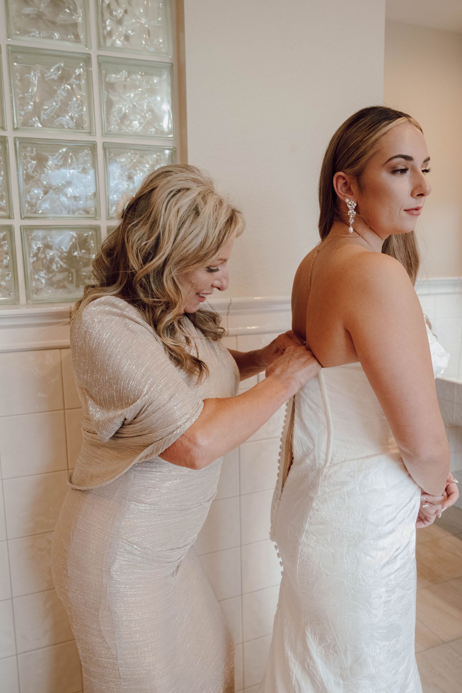 Wedding dress preparation scene with final adjustments being made.