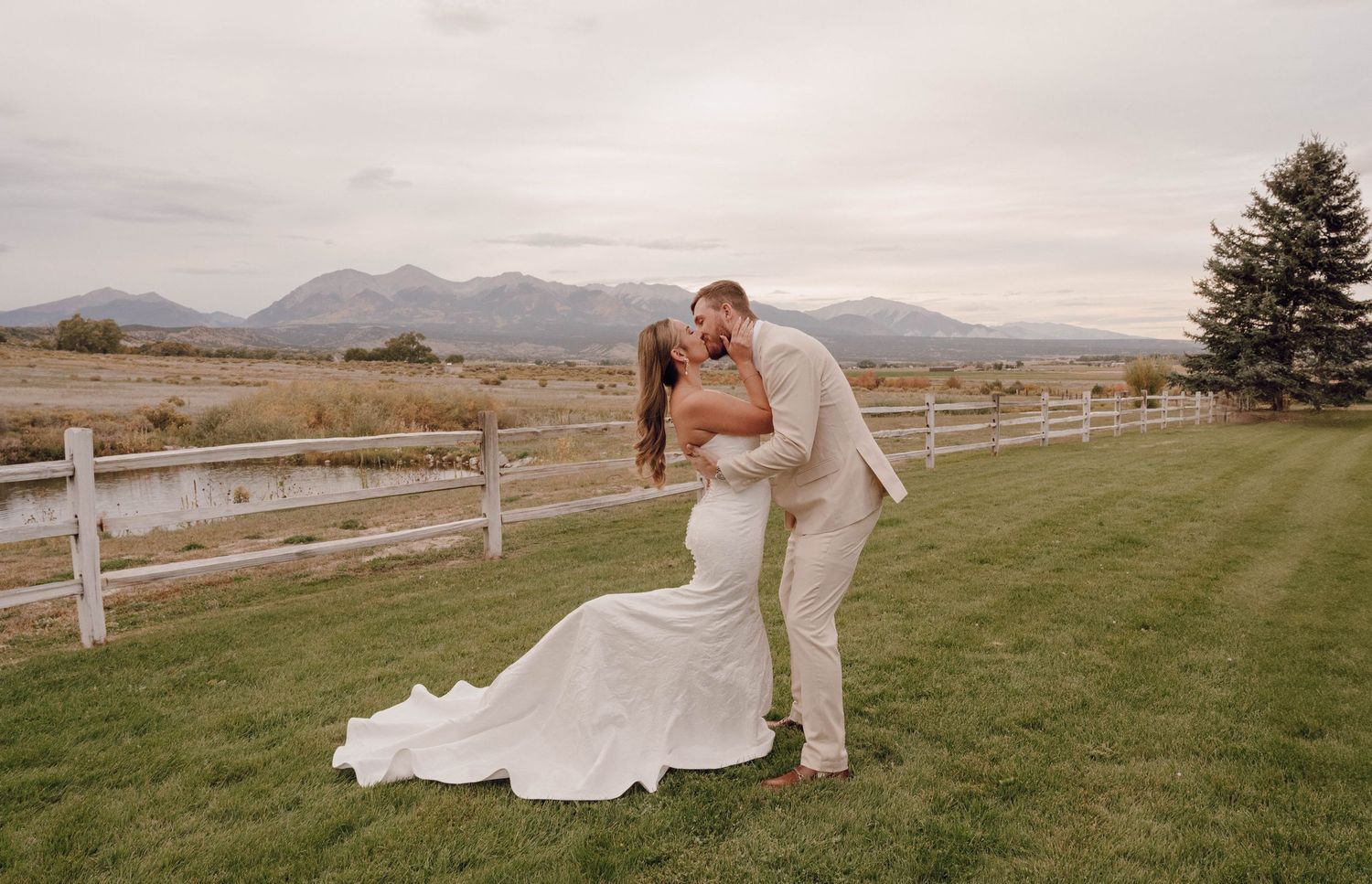 Panoramic view of an outdoor wedding ceremony setup with mountains in the background.