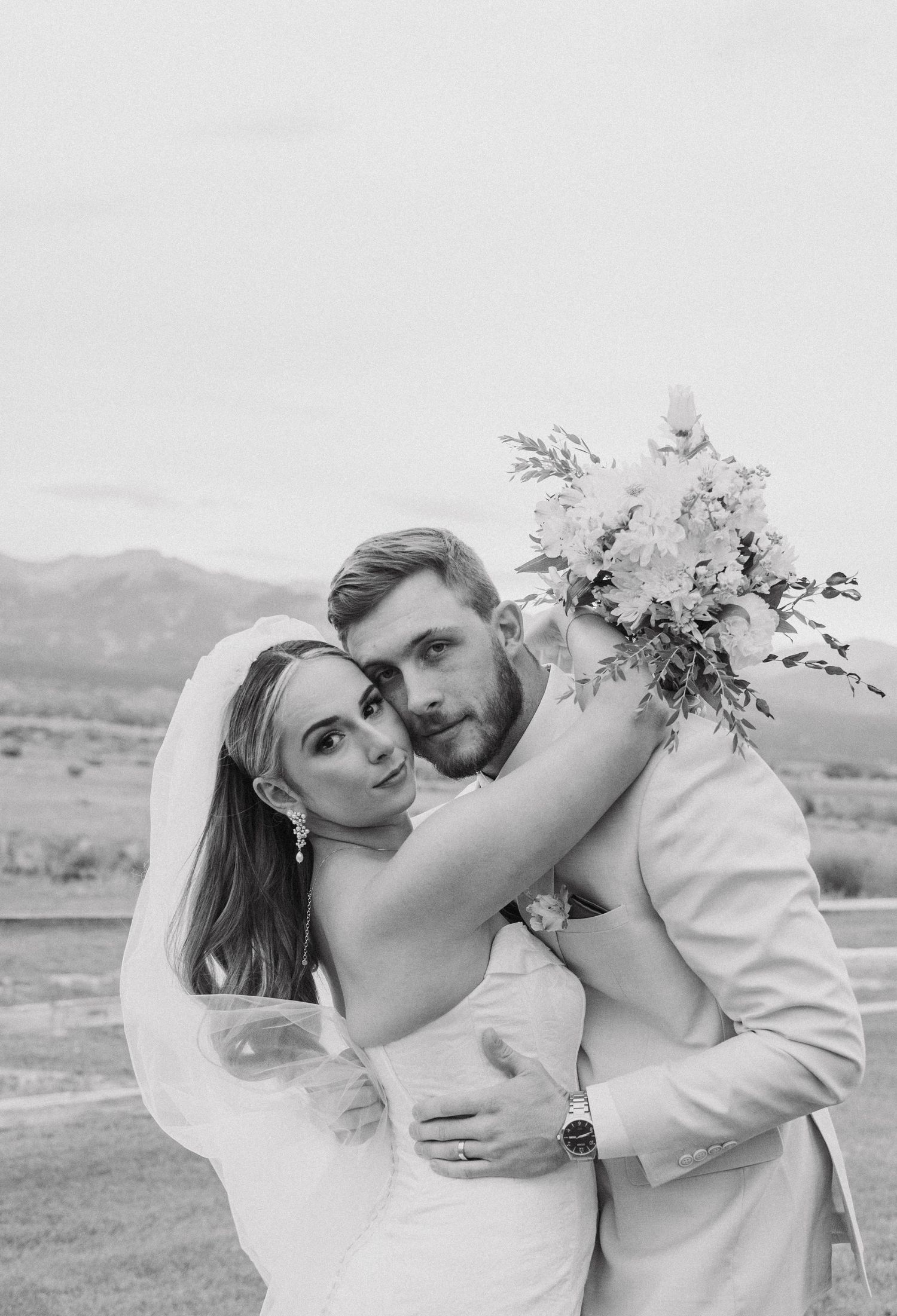 Black and white wedding portraits capturing intimate moments between the newlyweds outdoors.