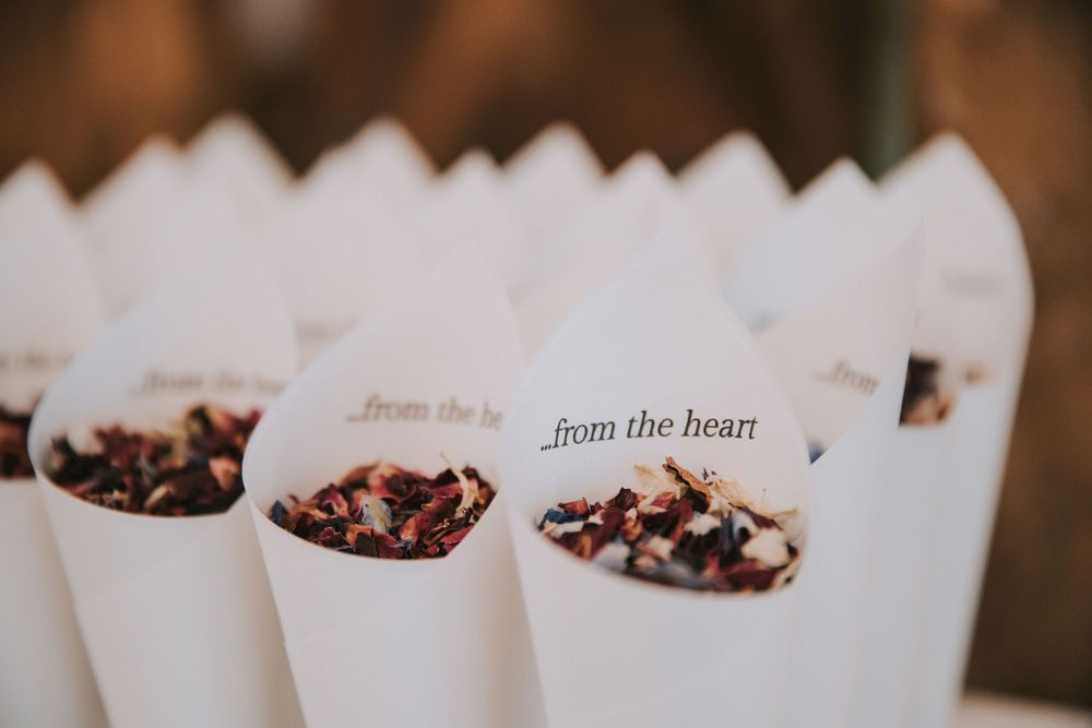 White paper cones filled with chocolate covered popcorn arranged in rows for an elegant dessert display.