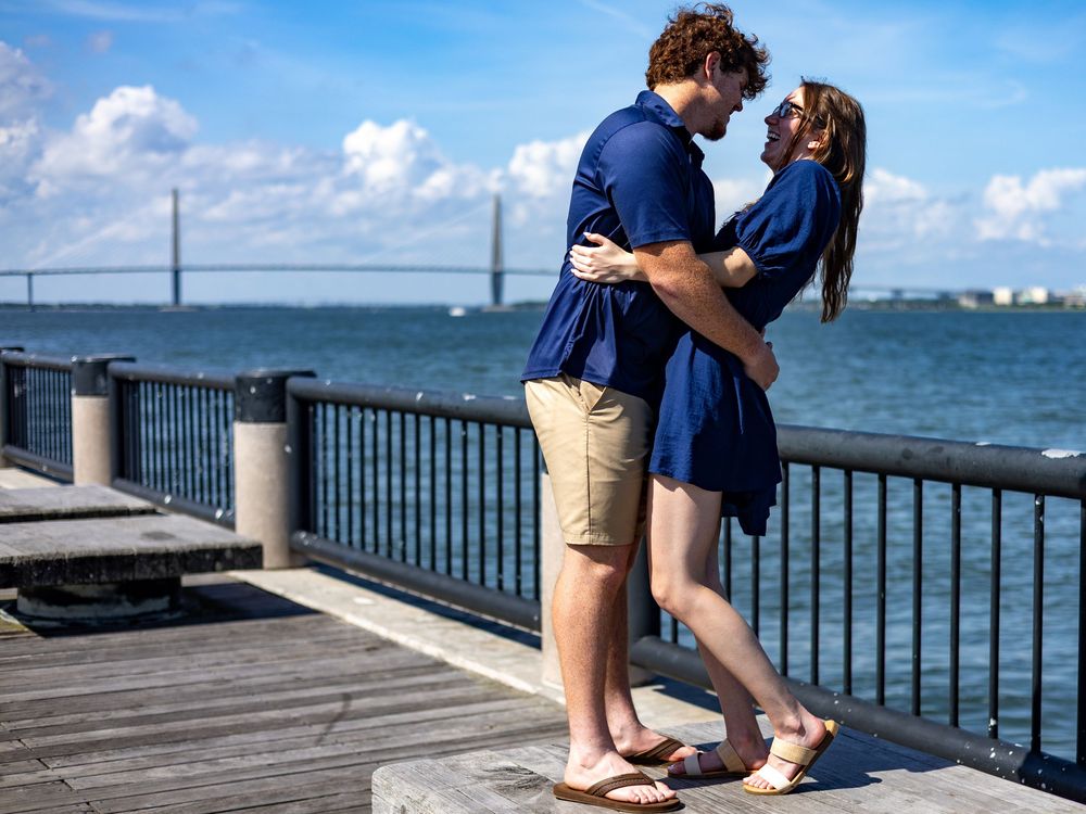 A romantic waterfront engagement photoshoot sequence showing a couple embracing on a pier with ocean views in the background.