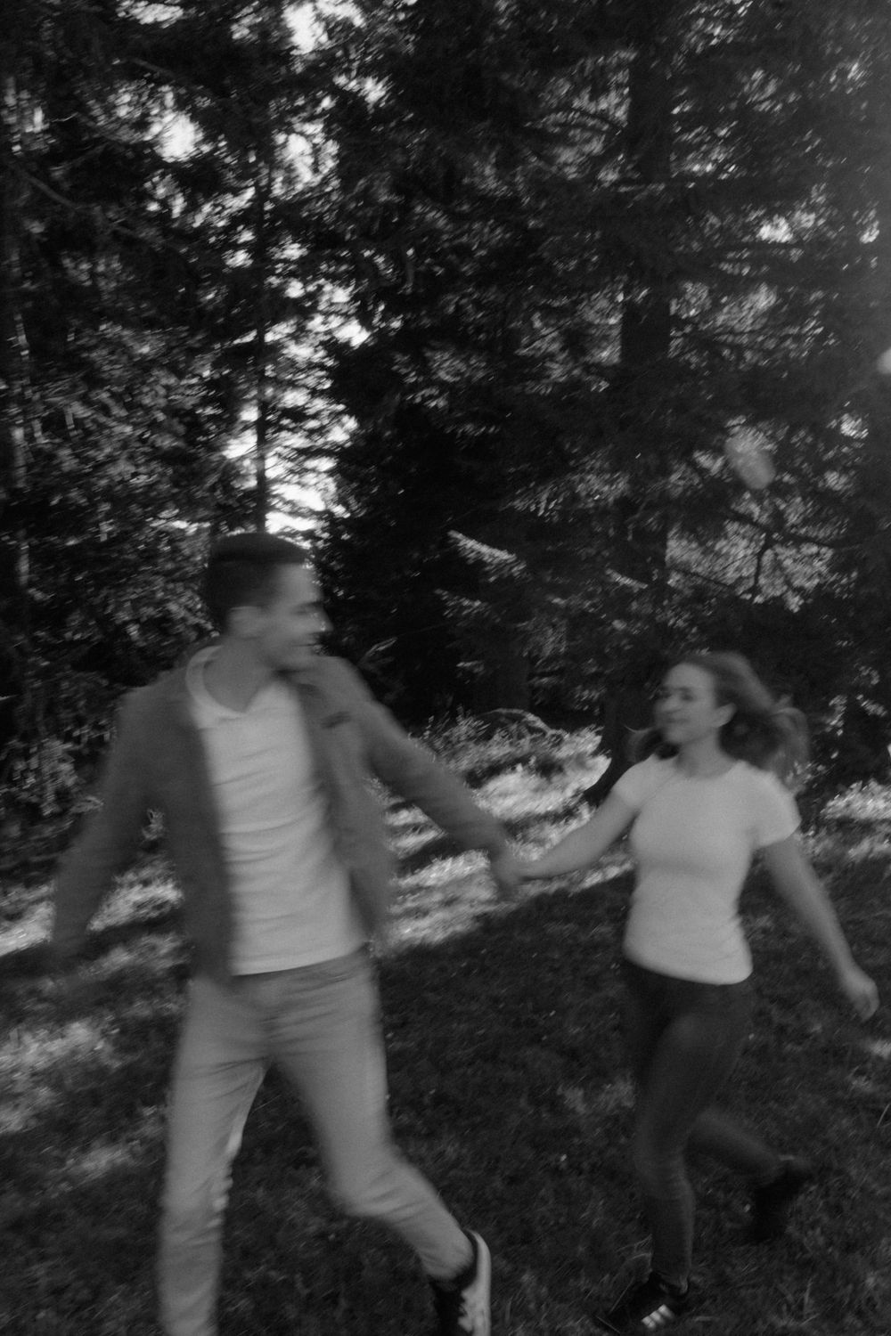 schwarz weiß Bild, Frau und Mann laufen Hand in Hand auf einer Wiese