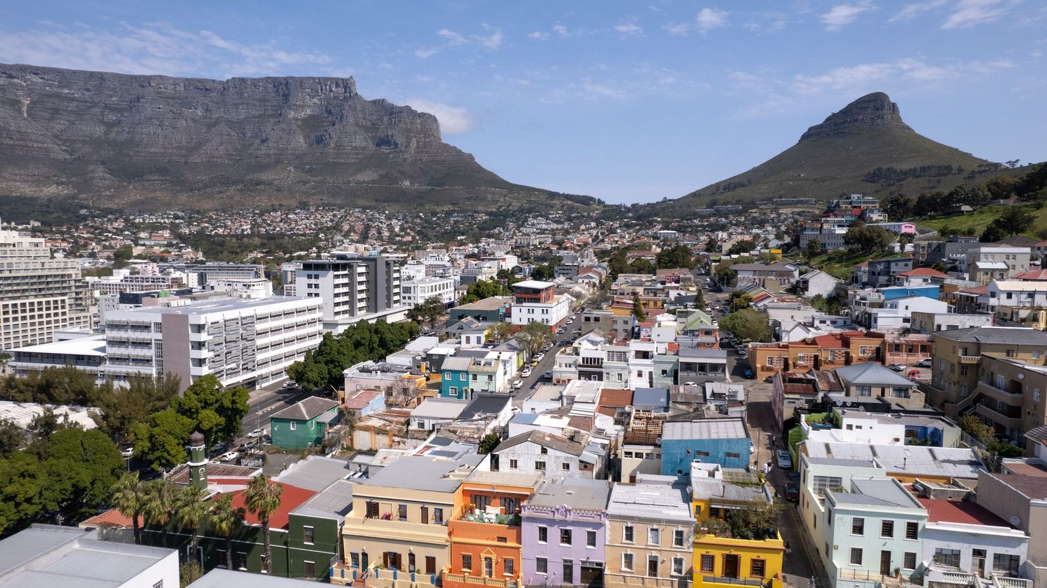 Colorful houses dot the hillside neighborhood with Table Mountain and Lion's Head in Cape Town.
