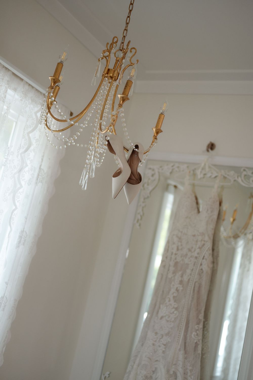 Brides wedding heels hanging on Chandelier at Wildberry Farms in South Carolina