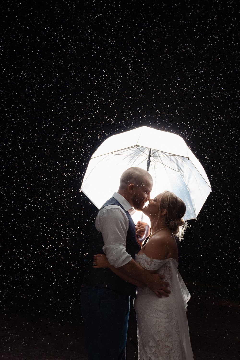 beautiful wedding photo under the umbrella in the rain